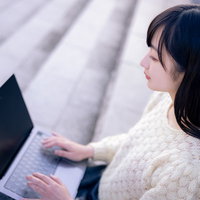 Macbookでコーディングする女子エンジニアの写真