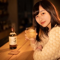 BARのカウンターで女性とウイスキーで乾杯する瞬間の写真
