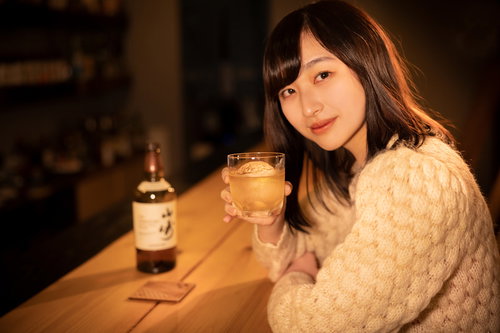 BARのカウンターで女性とウイスキーで乾杯する瞬間