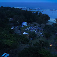 徳之島のアウトドアシアターで野外映画を楽しむ観客たちの写真