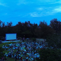 徳之島のアウトドアシアターで野外映画を楽しむ観客たちの写真