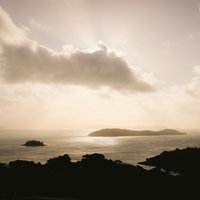 夕暮れ時の空と海に浮かぶ島々のシルエットの写真