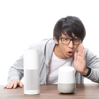 何度もスマートスピーカーに呼びかける眼鏡の男性の写真