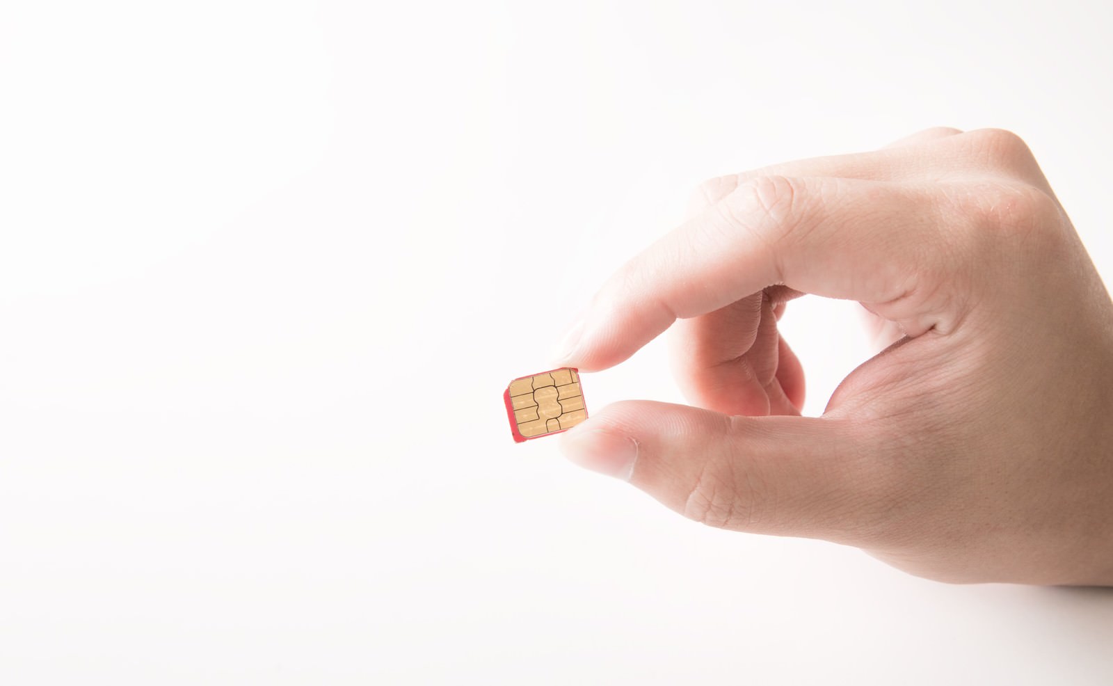 Hand holding a pink micro SIM card