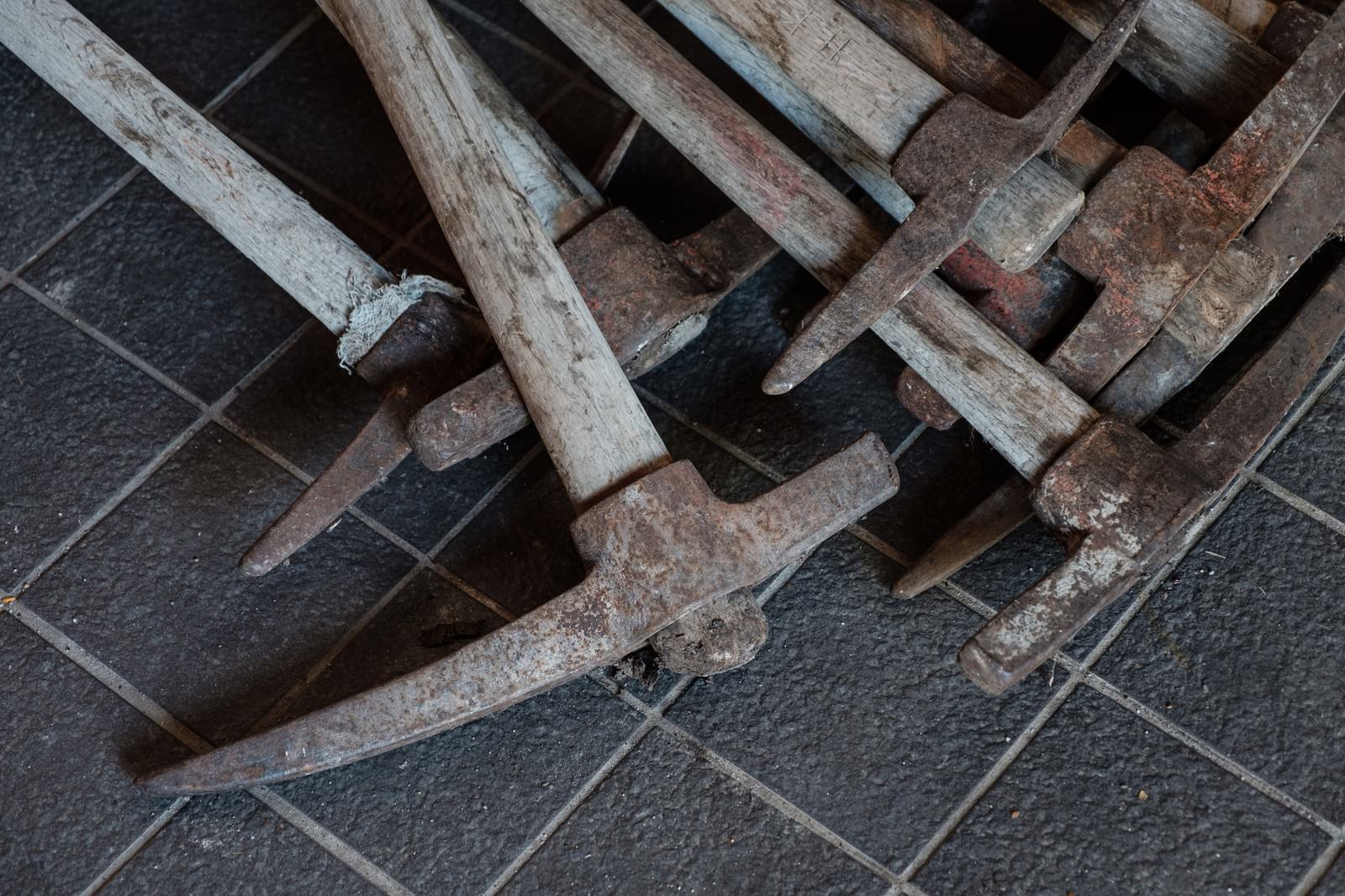 石畳の上に並べられた登山道整備用の複数のツルハシ
