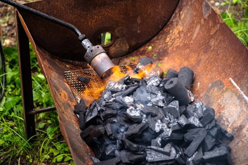 トーチバーナーで黒い木炭に火をおこす瞬間