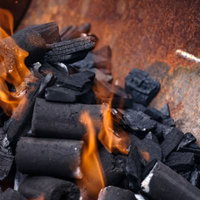 BBQの火起こし、木炭に燃え上がる炎とグリルの準備風景の写真