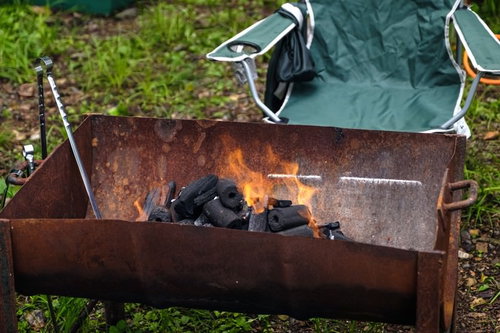 赤い炎が上がる半分にしたドラム缶のBBQグリル