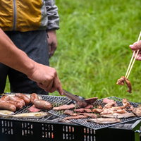 炭火でウィンナーやソーセージを焼く野外バーベキューの写真