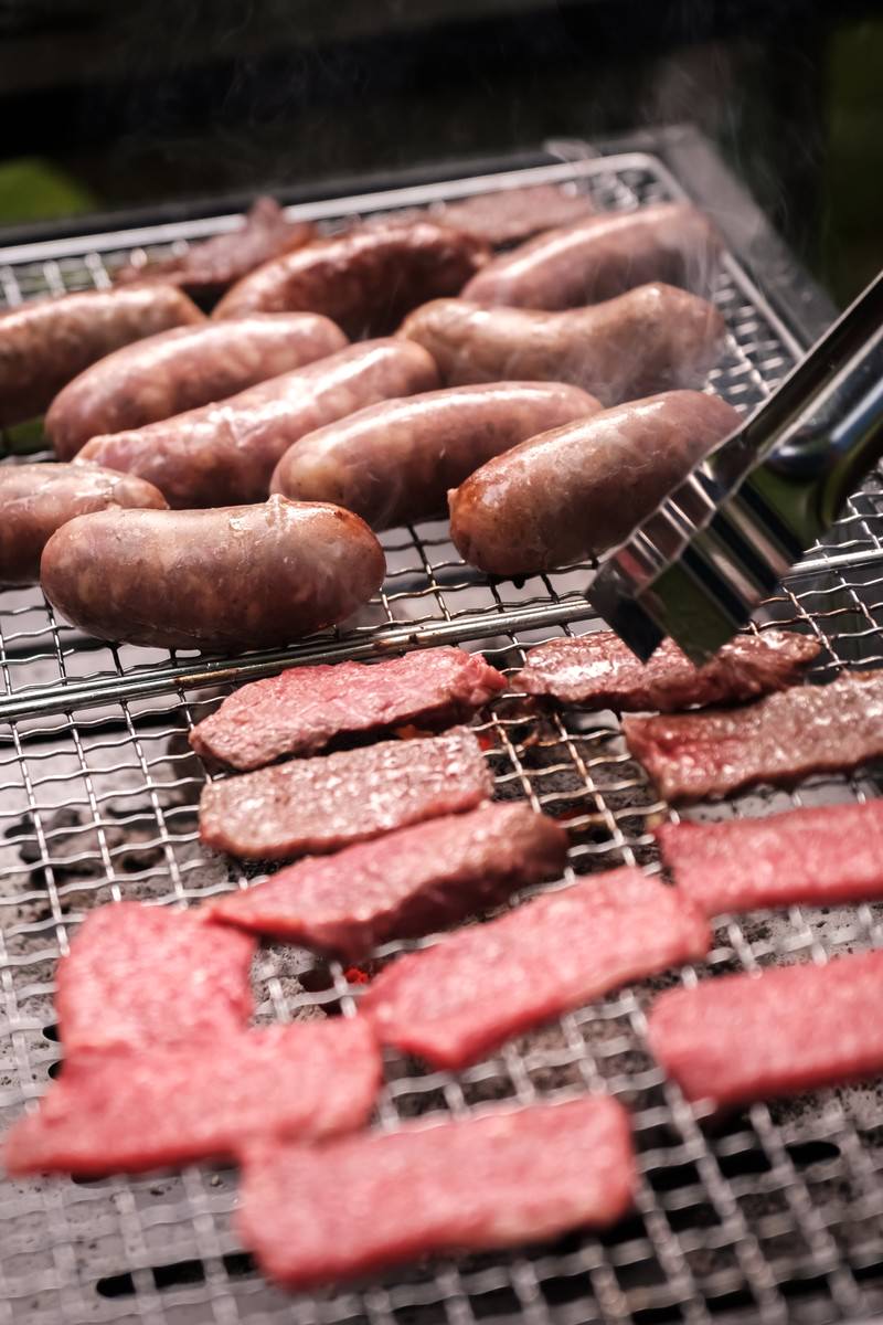 網の上で焼かれているソーセージと飛騨牛の炭火焼きBBQ