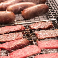 炭火で焼くウィンナーとハンバーグのBBQ・焼肉の写真
