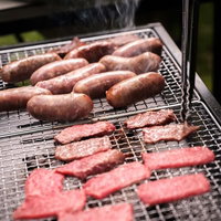 炭火で焼くソーセージと焼肉の野外バーベキューの写真