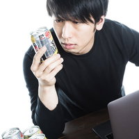 ストロングゼロを真剣に見つめる男性の写真