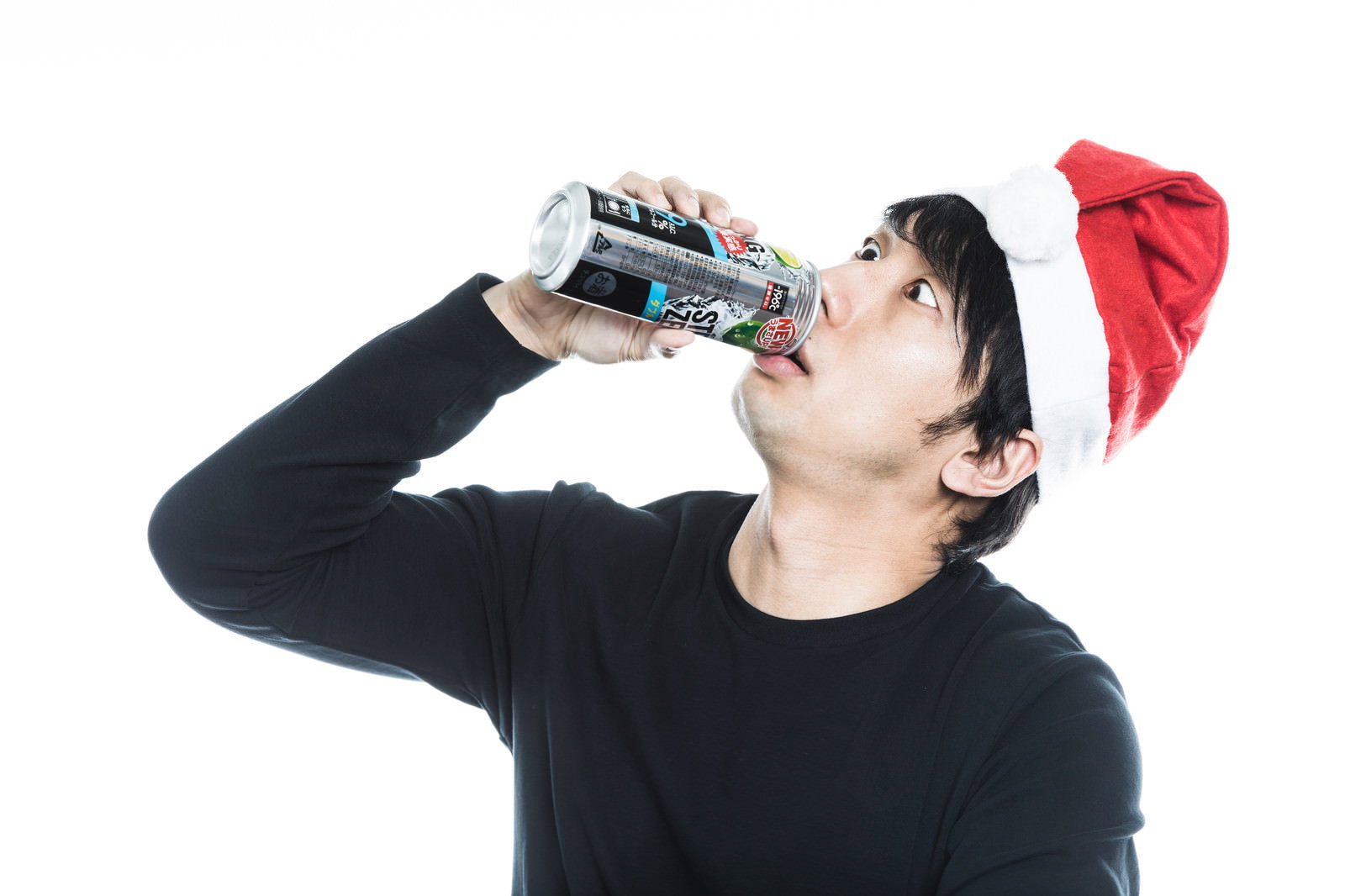 サンタ帽を被った男性が缶チューハイを飲んでいる様子［モデル：大川竜弥］