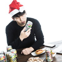 自分へのクリスマスプレゼントは缶チューハイ、サンタ帽をかぶる男性の写真