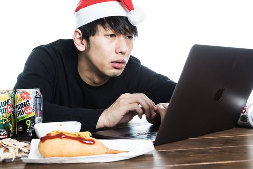 クリスマスイブに無料サンプル動画を見るサンタ帽子の男性