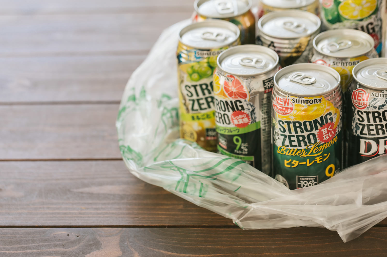 エコバッグに入ったストロングゼロなどの缶チューハイが木製テーブルに置かれている様子