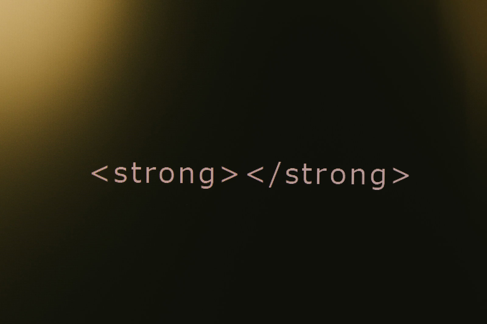 黒い背景にオレンジ色でHTMLのstrongタグが表示されたコード画面