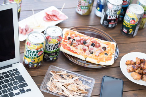 開発合宿の打ち上げで缶チューハイを飲むエンジニア