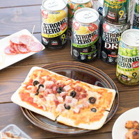缶チューハイとピザやつまみ類が並ぶテーブルの写真
