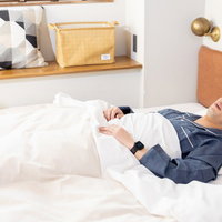 気づけば朝に......ベッドで熟睡する男性の写真