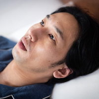 不眠で目覚めた男性がベッドで天井を見つめるの写真