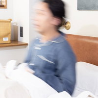 ガバッ......！寝坊して慌てて飛び起きる男性の写真