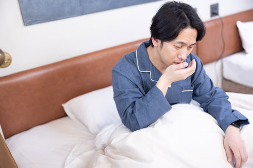 寝起きの口臭が気になり咳をする男性