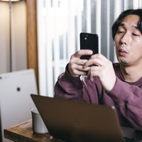 仕事に集中できずついスマホを見てしまう男性の写真