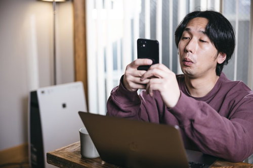仕事に集中できずついスマホを見てしまう男性