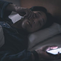 寝ているところに通知が届いて目を覚ますところの写真