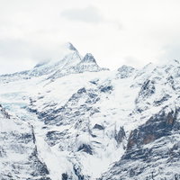 グリンデルワルトの雪山と山小屋の写真