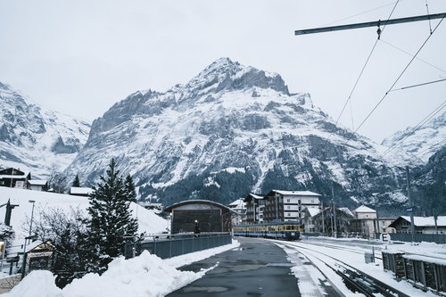 グリンデルワルト（スイス）を走行する電車と雪山
