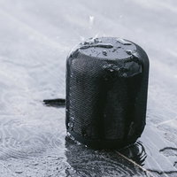 防水のワイヤレススピーカーに水をかける様子の写真