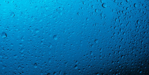 窓の結露と雨粒でかすむ車のフロントガラス