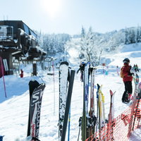 ゲレンデに立てられたスキー板とリフト、雪景色の写真