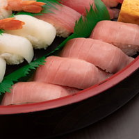出前用の黒い漆器に盛り付けたまぐろの赤身寿司の写真