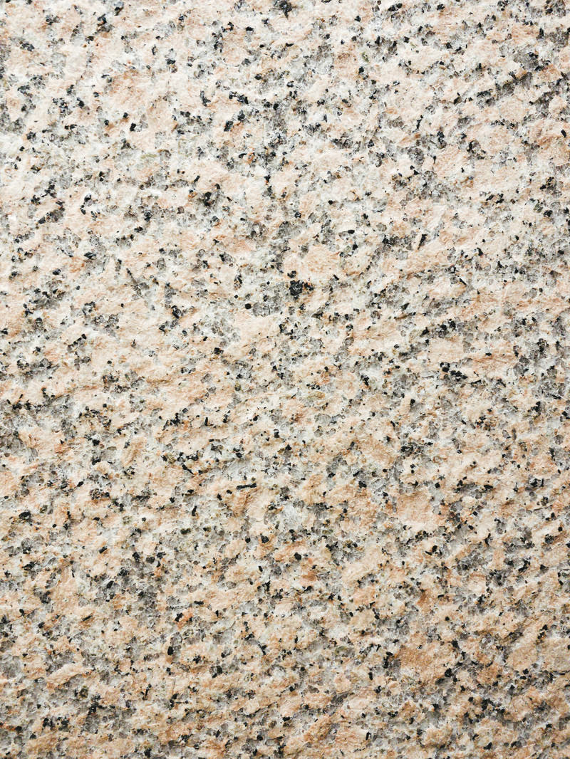 ベージュと茶色の細かい斑点が散らばった御影石の表面テクスチャー