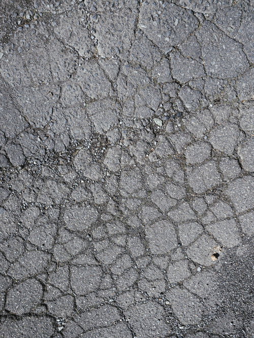 ひび割れたアスファルト舗装面のテクスチャー