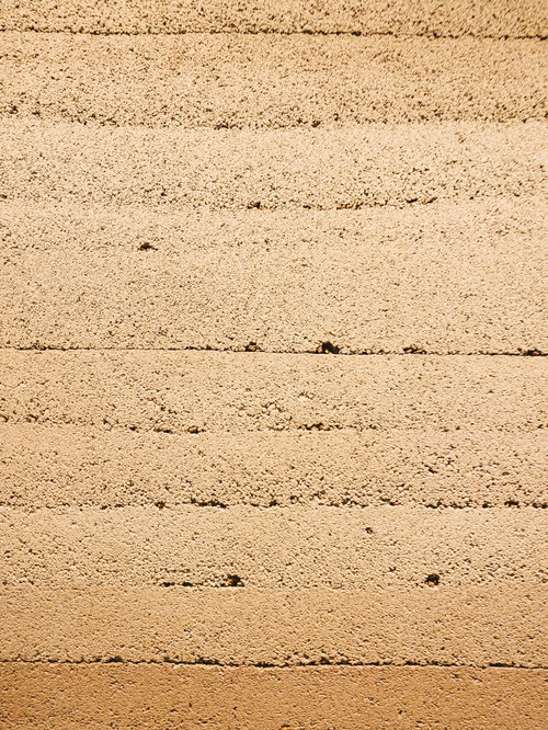 何層にも重なるベージュの石材とレンガの壁