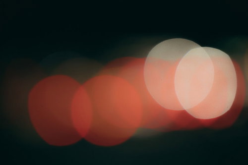 暗闇に連なる赤い光源と玉ボケの夜景背景