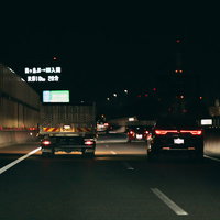 夜間の高速道路を走るトラックのテールランプの写真