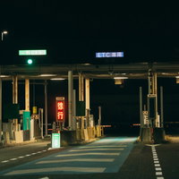 夜間走行時の高速道路ETC専用レーンの料金所ゲートの写真