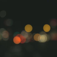 暗い背景に重なるカラフルなオレンジと黄色のボケ味の写真