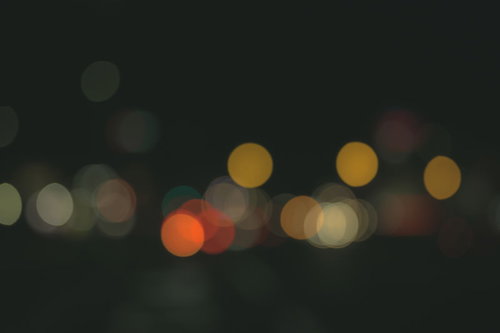 暗い背景に重なるカラフルなオレンジと黄色のボケ味