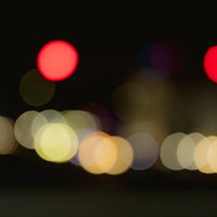 赤と桃色に縁どられた光の玉ボケの写真