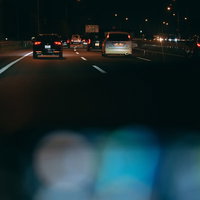 運転席から見る夜の高速道路の渋滞とテールランプの写真