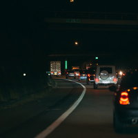 夜間走行する高速道路の連なるテールランプと車間距離の写真