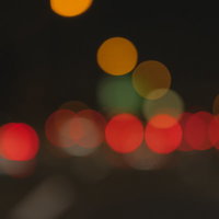 夜景の遠景に見える赤いテールランプのボケの写真