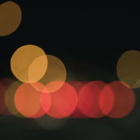 暗闇に舞うオレンジ色のボケと玉ボケ、温かい光の背景の写真